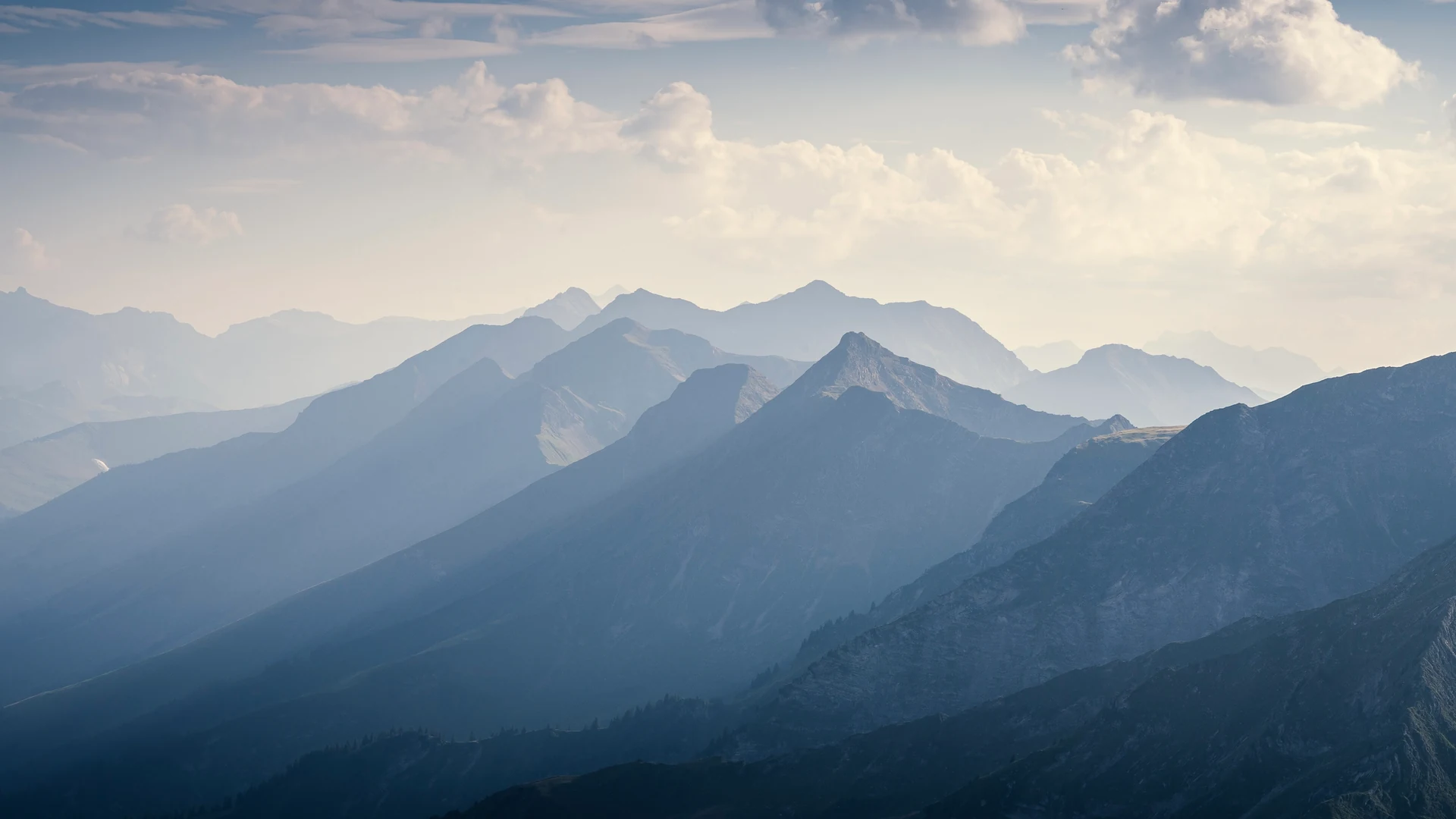 Les plans de montagnes se succèdent dans une lumière bleutée.